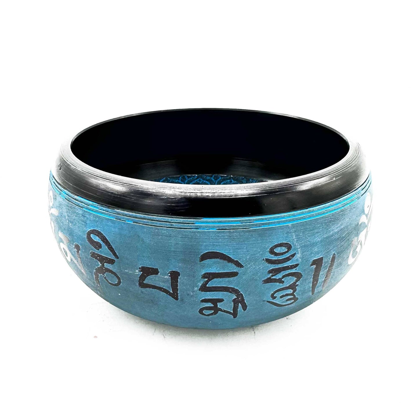 Un bol tibétain bleu en poudre de terre, décoré de mantras noirs.