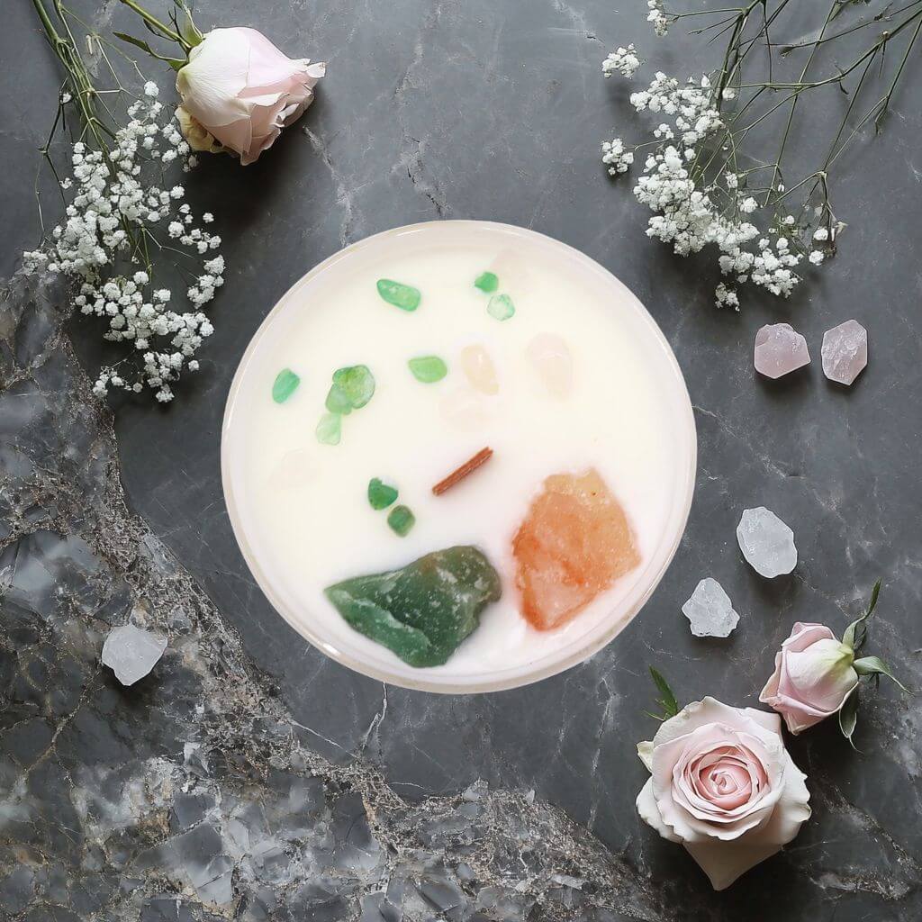 Bougie Chakra du Cœur - Anhata avec pierres naturelles vertes de jade et rose de quartz sur marbre avec décoration.