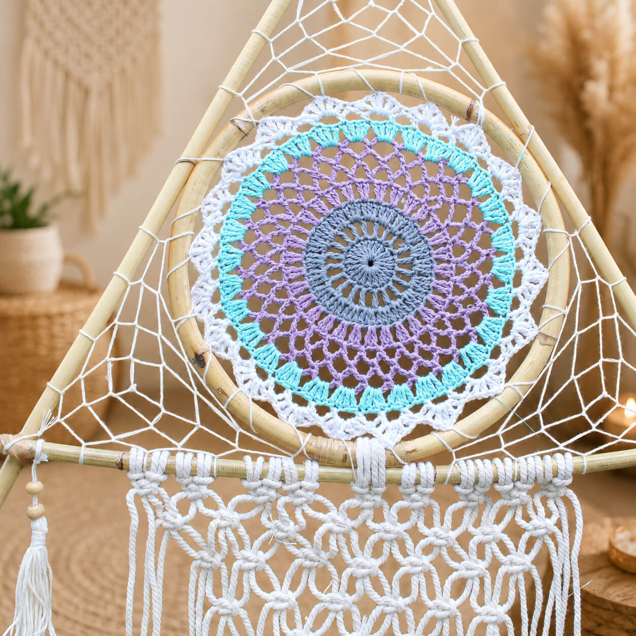 Détail du médaillon crocheté central avec mandala turquoise, lilas et gris ardoise dans son cadre triangulaire.