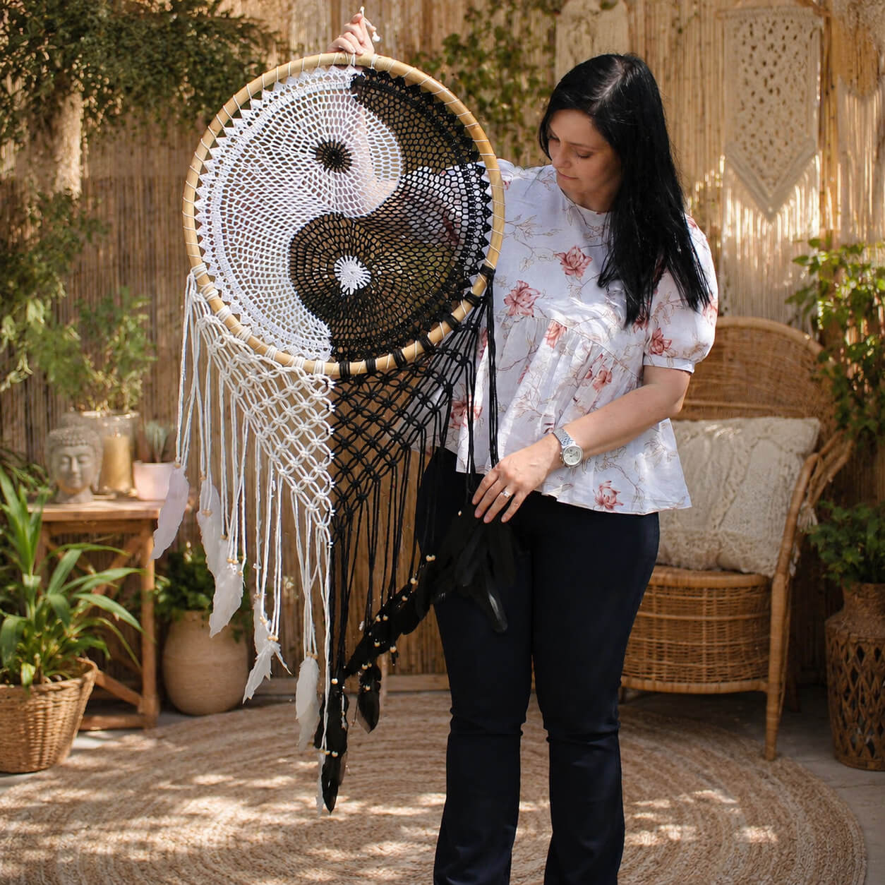 Attrape-rêve géant yin yang présenté à hauteur de femme pour montrer son envergure de 135 cm.
