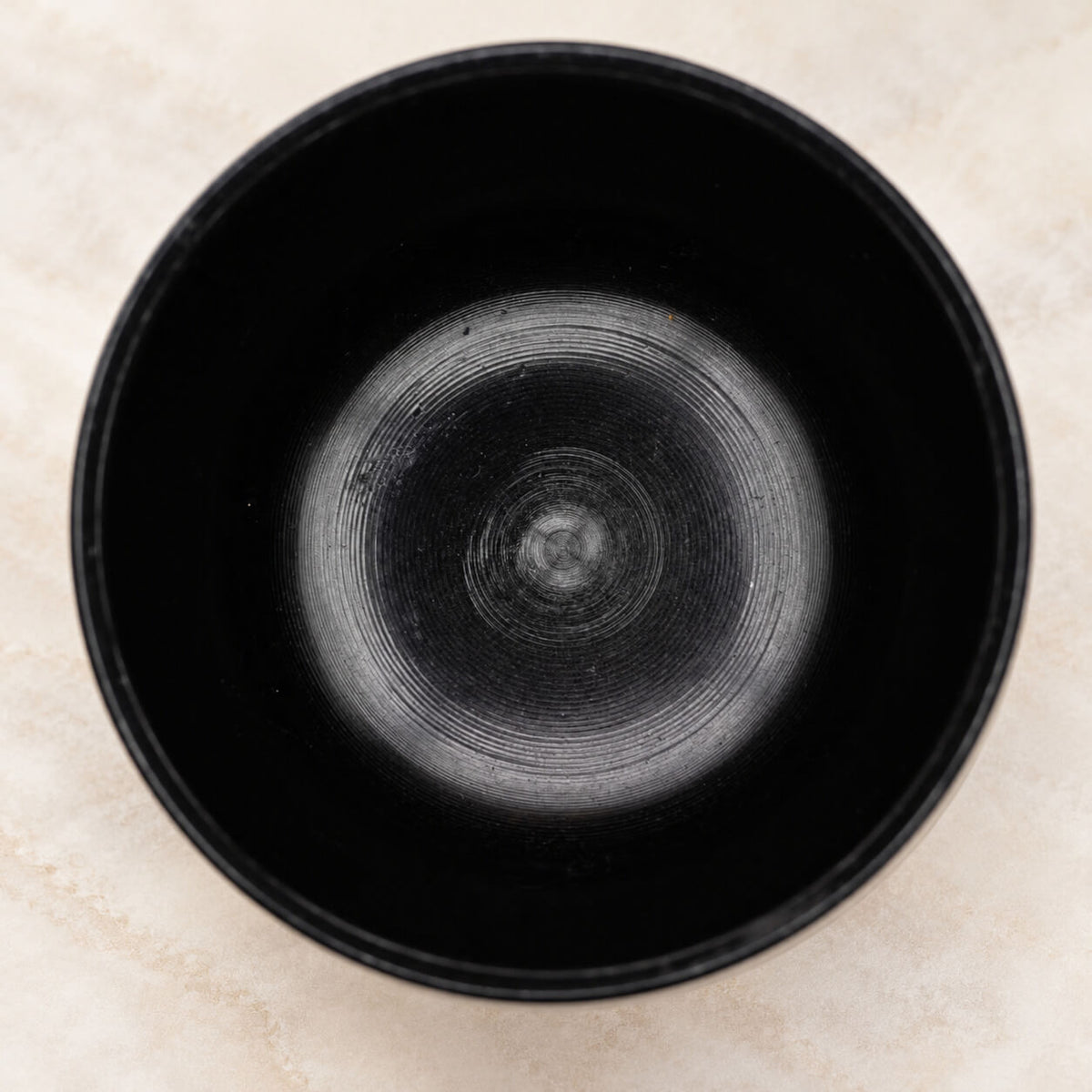 Intérieur noir du bol chaudron vu du dessus, fins cercles de tournage au fond