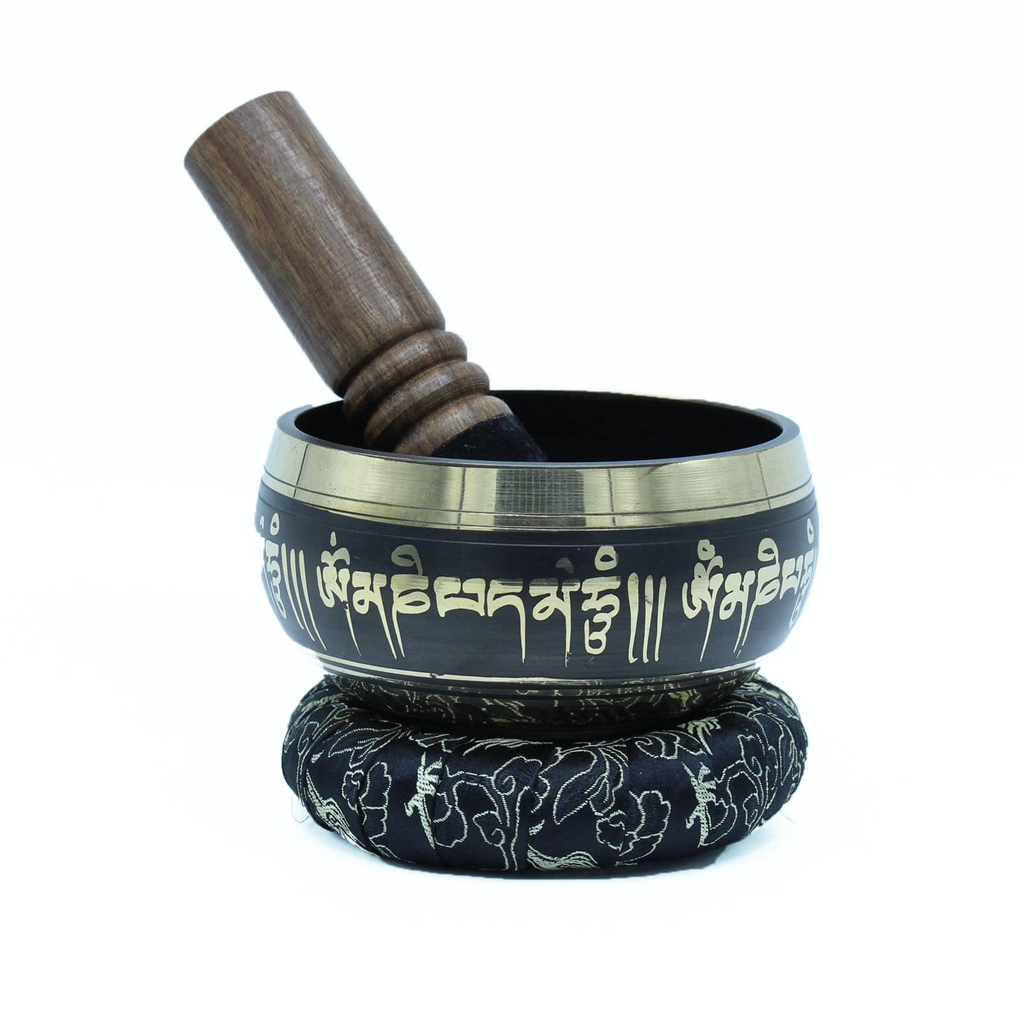 Un bol tibétain noir avec des bordures dorées et des mantras dorés gravés, posé sur un coussin. À l'intérieur du bol se trouve un fuseau en bois, prêt à être utilisé.
