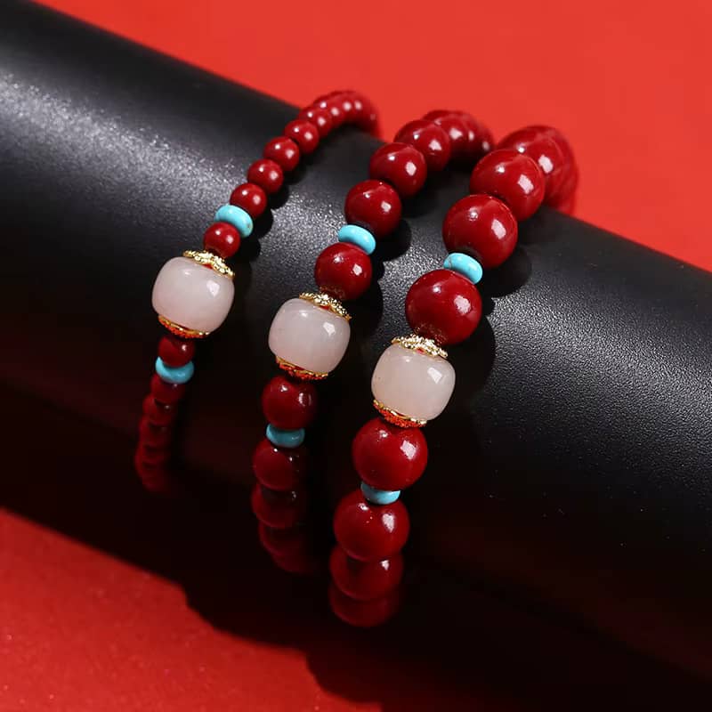 Trois variations du bracelet en cinabre rouge, quartz rose et turquoise sur support noir.