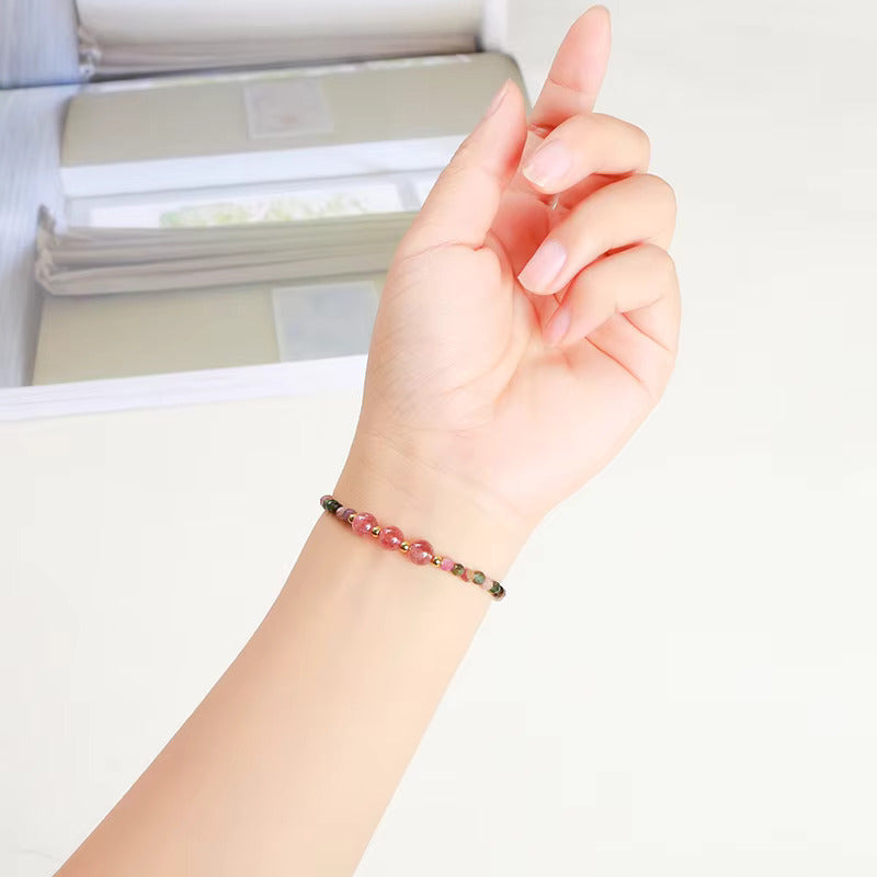 Bracelet fin de tourmaline porté au poignet, montrant la délicatesse des perles sur la peau.