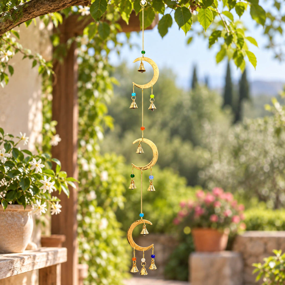 Carillon à vent à trois lunes en laiton avec clochettes dorées et perles multicolores, suspendu sous un arbre