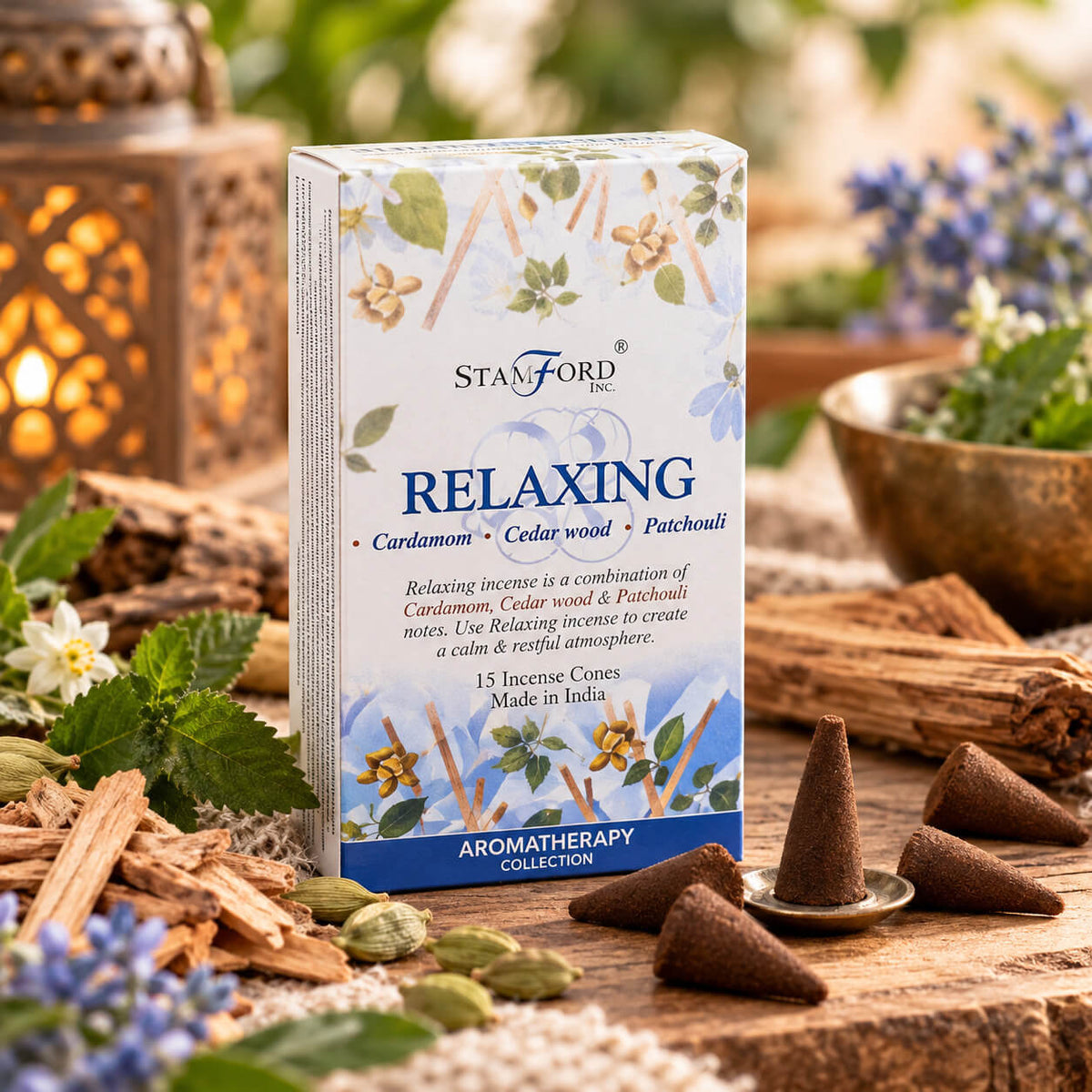 Boîte de cônes d'encens Relaxation aux notes de cardamome, de bois de cèdre et de patchouli, cônes près d'une coupelle, gousses de cardamome et copeaux de bois en décor