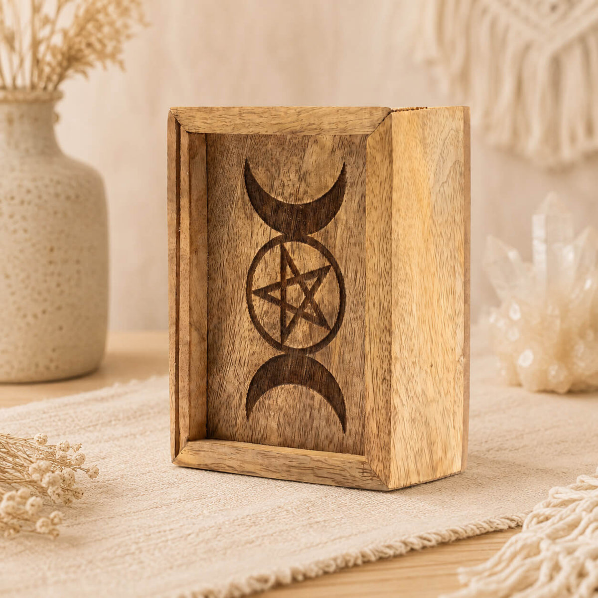 Détail du présentoir en bois gravé de croissants de lune et d'un pentacle
