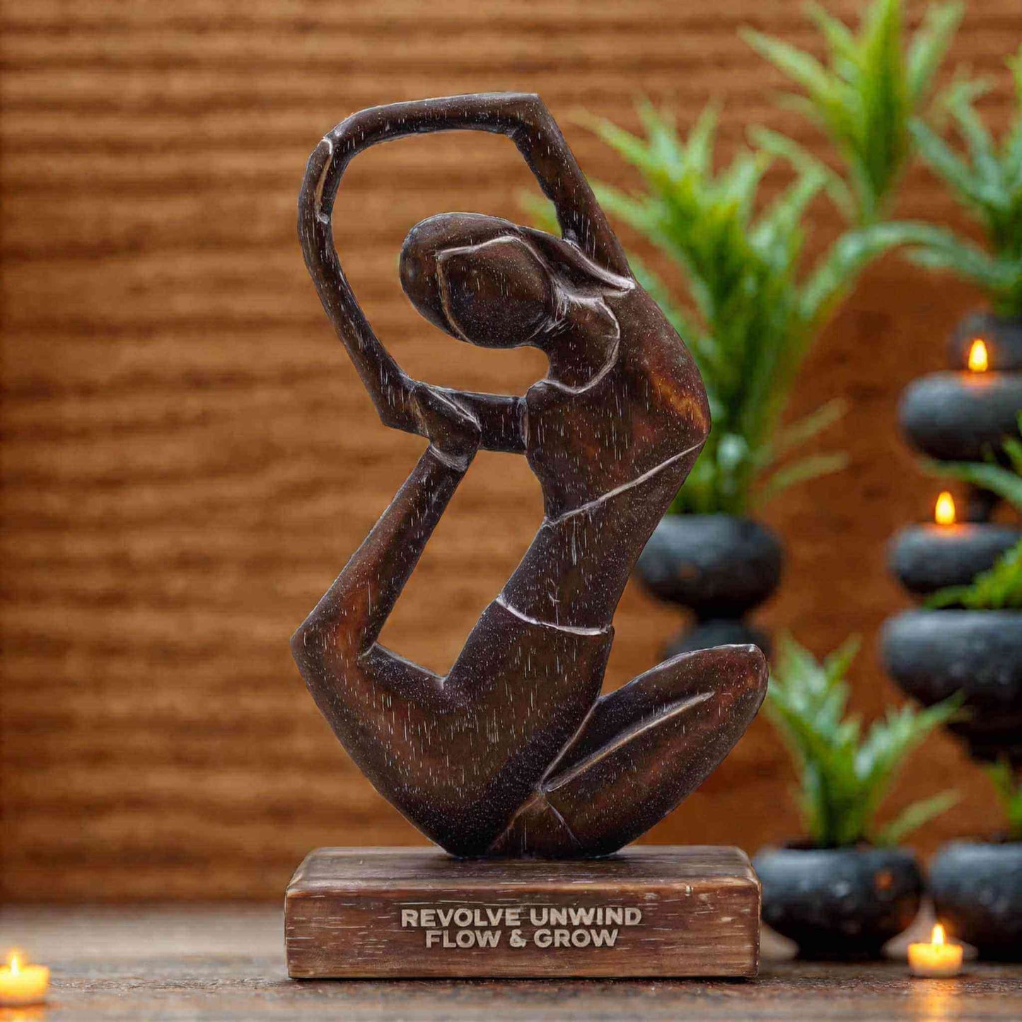 Statuette yoga demi-lune en bois sombre sur socle, décor zen avec bougies allumées et plantes vertes, ambiance spirituelle et apaisante.