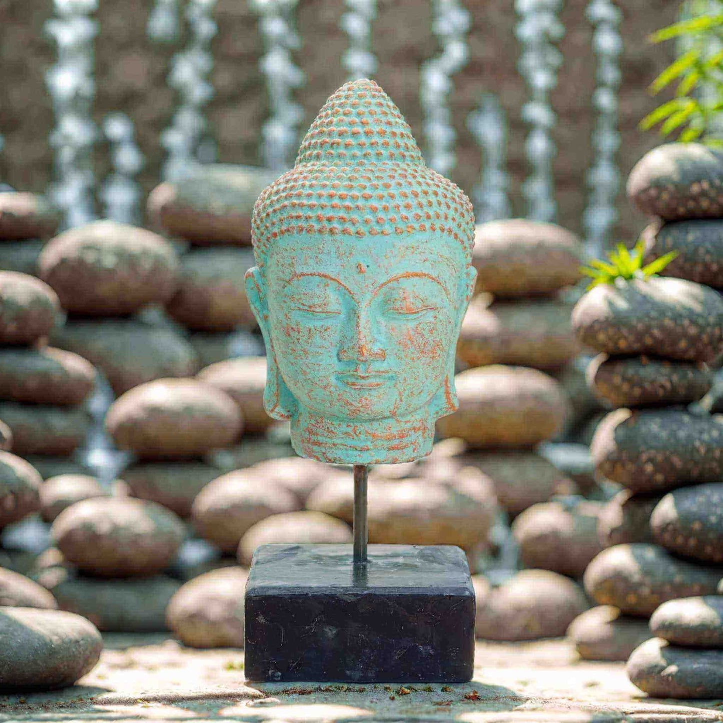 tête de Bouddha en béton patiné cuivre vert sur support en bois noir, sculpture artisanale indonésienne 30 cm pour décoration zen et méditative.