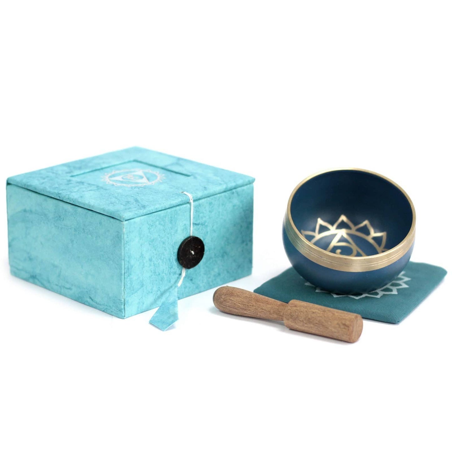 Coffret fermé bleu turquoise contenant un bol tibétain bleu turquoise avec une bordure dorée. À l'intérieur, le symbole du Chakra Gorge doré, posé sur un tapis bleu turquoise, accompagné d'un fuseau en bois.