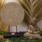 Statue Bouddha en bois avec mandalas décoratifs en beige présentée sur support rustique avec bougie et décor d'épis de blé et feuillages.