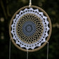 Détail du médaillon crocheté en mandala blanc et gris bleuté sur cerceau enroulé de jute naturel.