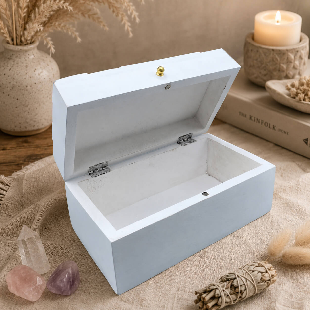 Boîte à bijoux blanche ouverte, intérieur laqué blanc et charnières apparentes.