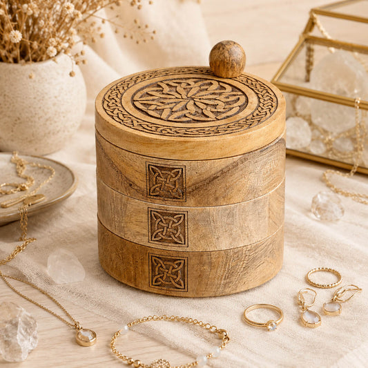 Boîte à bijoux celtique fermée avec bijoux dorés et cristaux disposés en mise en scène