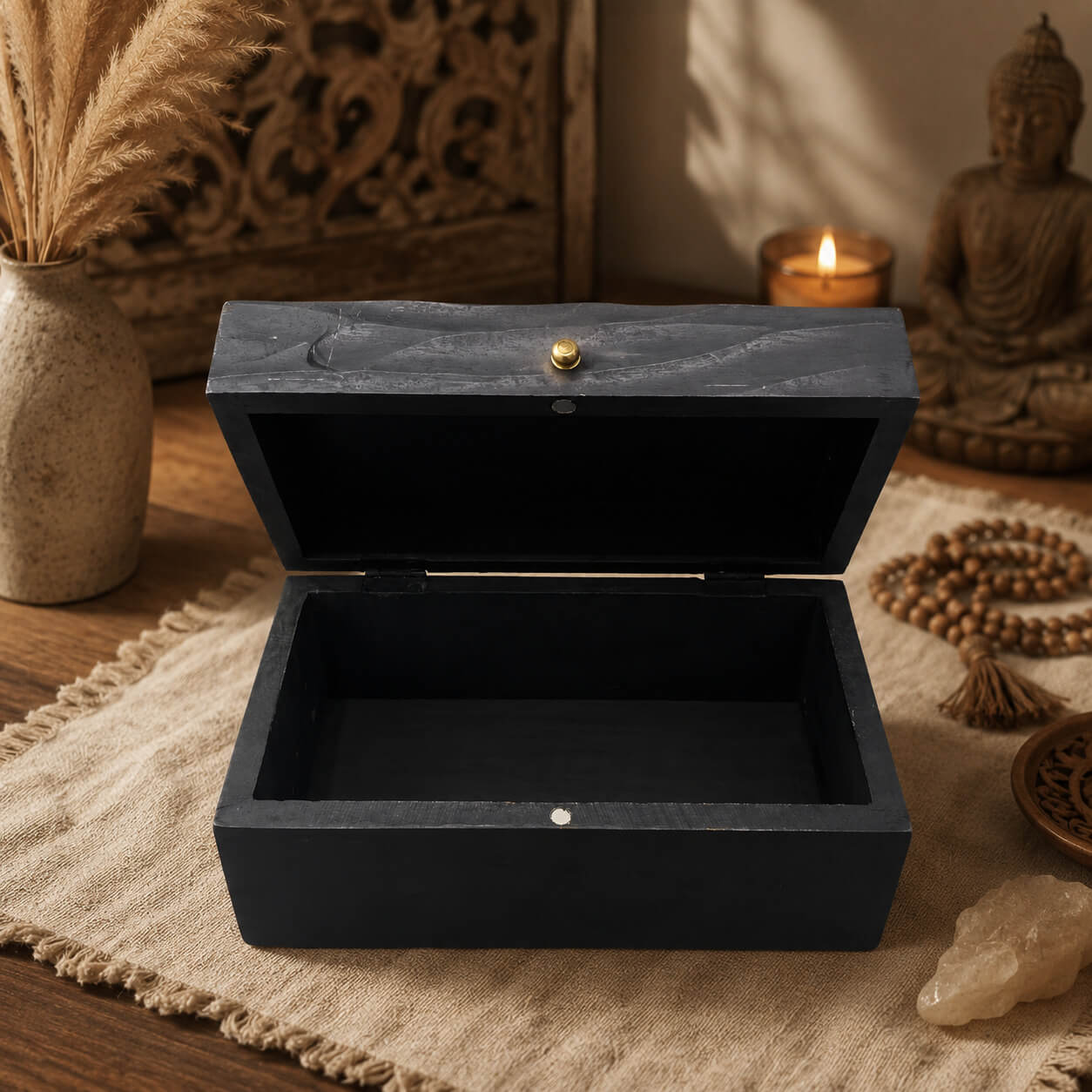 Boîte à bijoux noire ouverte, intérieur laqué noir et fermeture à charnières.