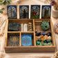 Boîte de tarot avec compartiments illustrés par des cristaux, cartes et objets rituels en mise en scène