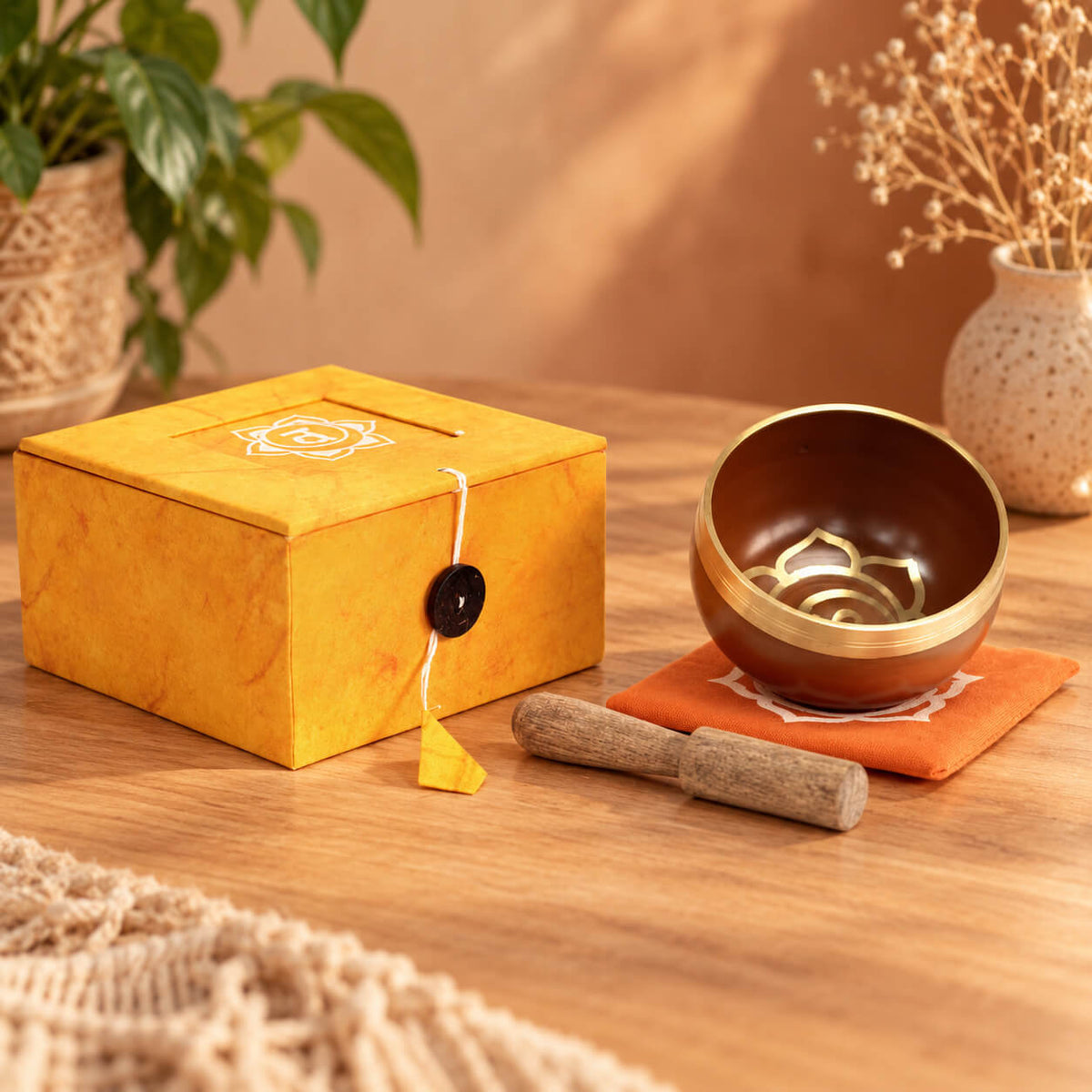 Bol chantant orange et or du chakra sacré sur son coussin, avec son bâton en bois et sa boîte safran fermée