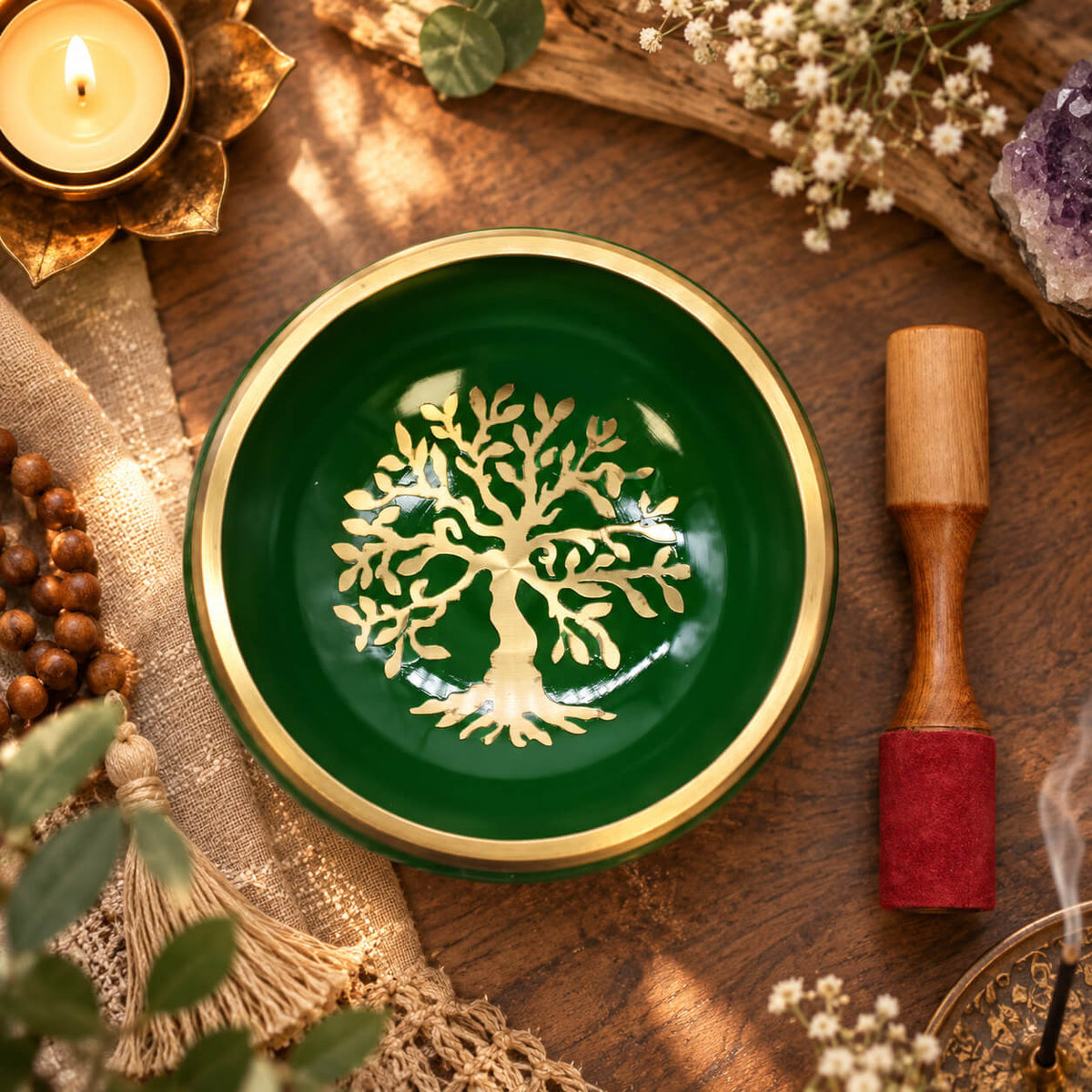 Bol chantant tibétain vert orné de symboles Om dorés, posé sur son coussin vert sapin avec son bâton en bois