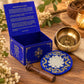 Coffret bleu ouvert près du bol chantant martelé, Bouddha de Médecine en relief au fond du bol