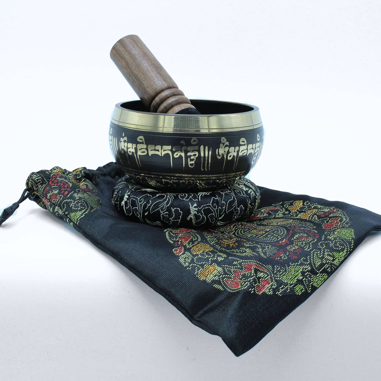Un bol tibétain noir avec des bordures dorées et des mantras dorés gravés, posé sur un coussin qui est lui-même placé sur un sac assorti.