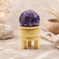 Boule d'améthyste violette posée sur son support tripode en bois
