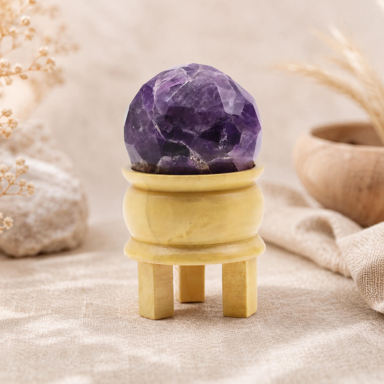 Boule d'améthyste violette posée sur son support tripode en bois