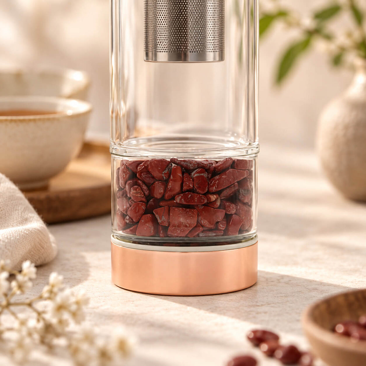 Détail du compartiment à éclats de jaspe rouge au pied de la bouteille à thé en verre