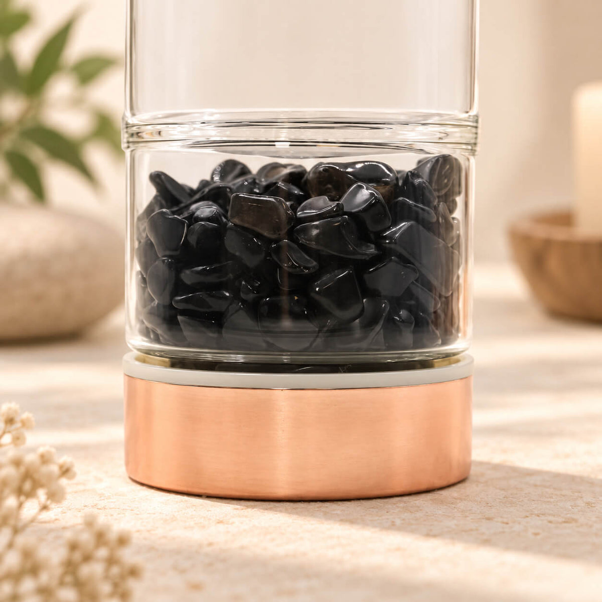 Détail du compartiment à éclats d'onyx noir au pied de la bouteille à thé en verre