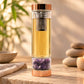 Bouteille à thé en verre avec infusion dorée et éclats d'améthyste à la base