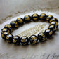 Bracelet tibétain en obsidienne noire avec mantra Om Mani Padme Hum gravé en or sur fond ancien.