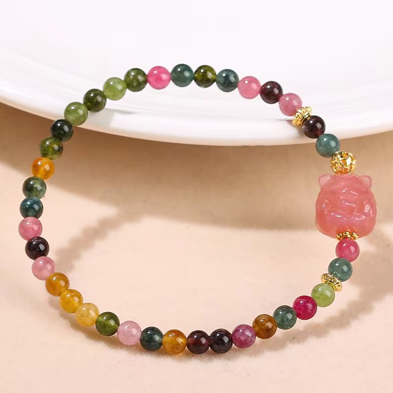 Bracelet tourmaline multicolore avec perles de 4mm et renard rose sculpté, détails dorés sur fond blanc.