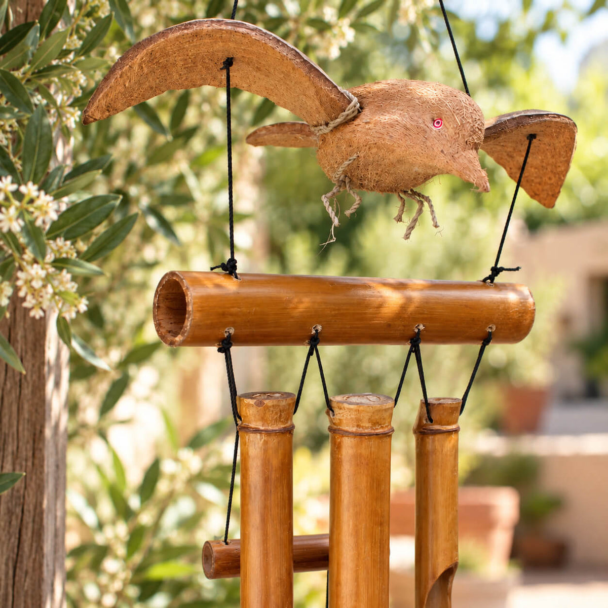 Gros plan sur l'oiseau en fibre de coco du carillon en bambou, ailes sculptées façon artisanat balinais