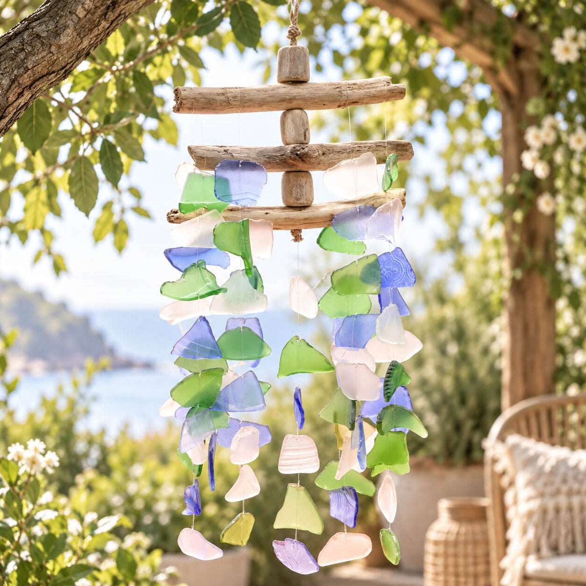 Carillon à vent en verre recyclé multicolore (bleu, vert, rose, blanc) sur structure à trois barres de bois flotté