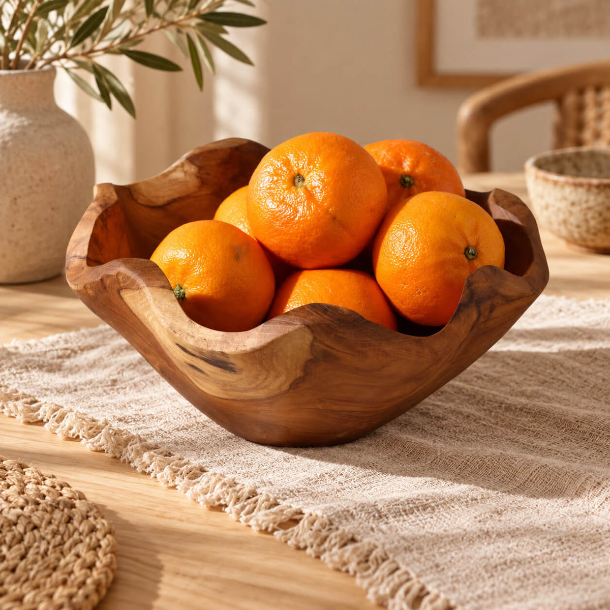 Coupe en bois de teck remplie d'oranges fraîches