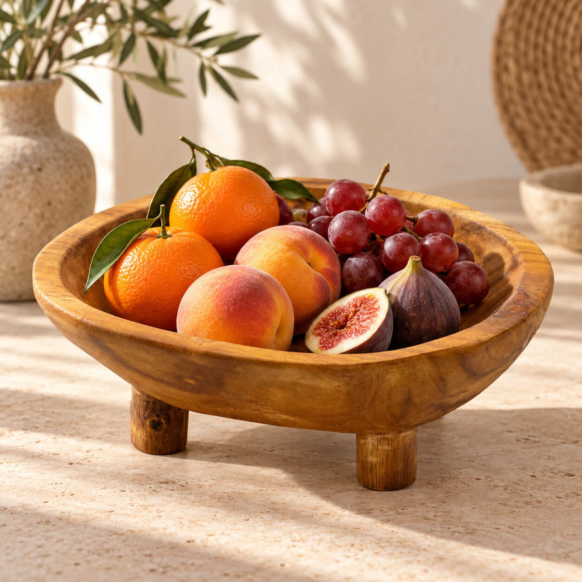 Coupe en teck sur pieds garnie d'oranges, pêches, raisins et figues