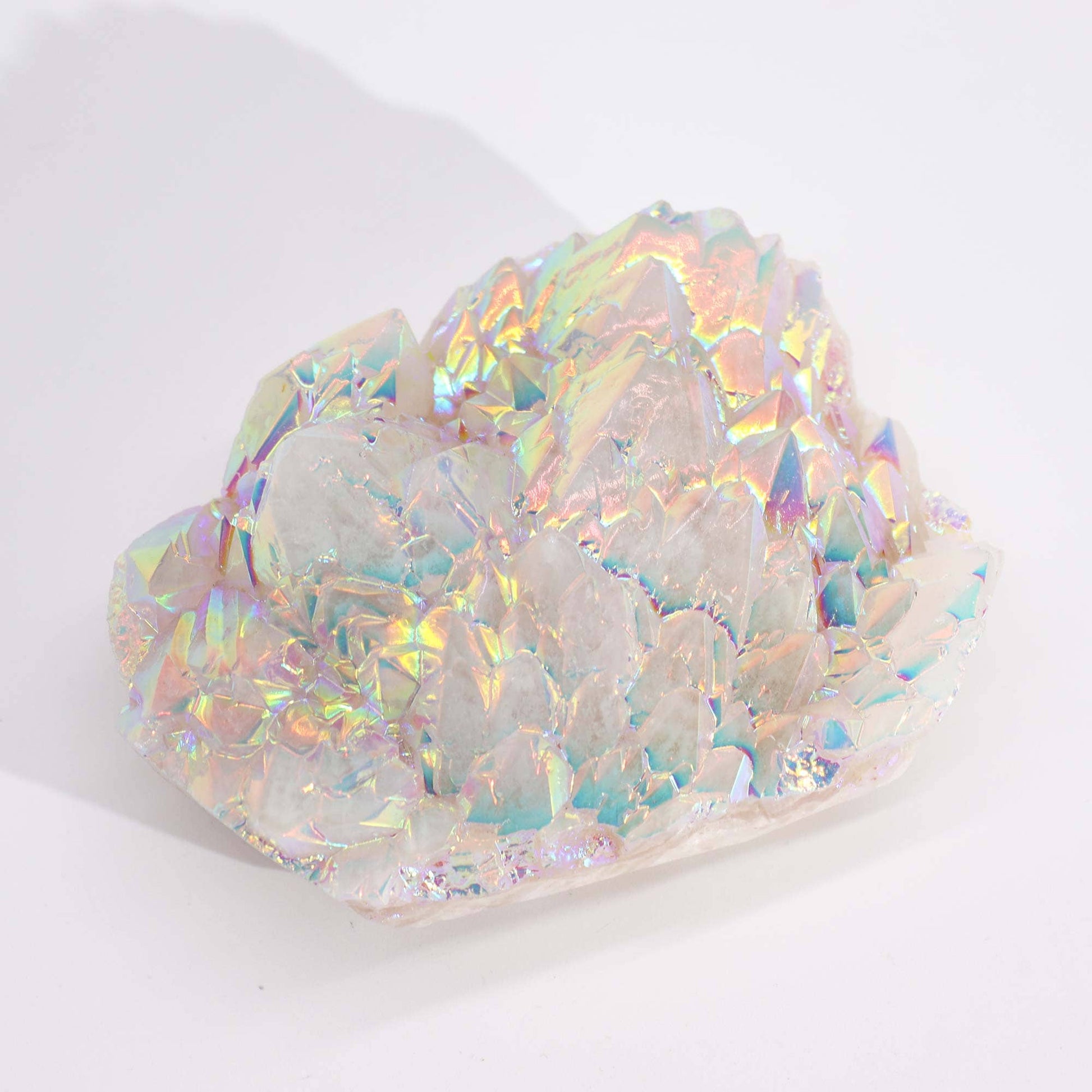 Vue aérienne d'un Quartz Aura Angélique mettant en évidence sa forme cristalline élancée et ses reflets iridescents arc-en-ciel qui couvrent toute sa surface. La lumière se reflète sur le cristal, créant une lueur mystique et accentuant la clarté et la finition unique de ce précieux quartz.