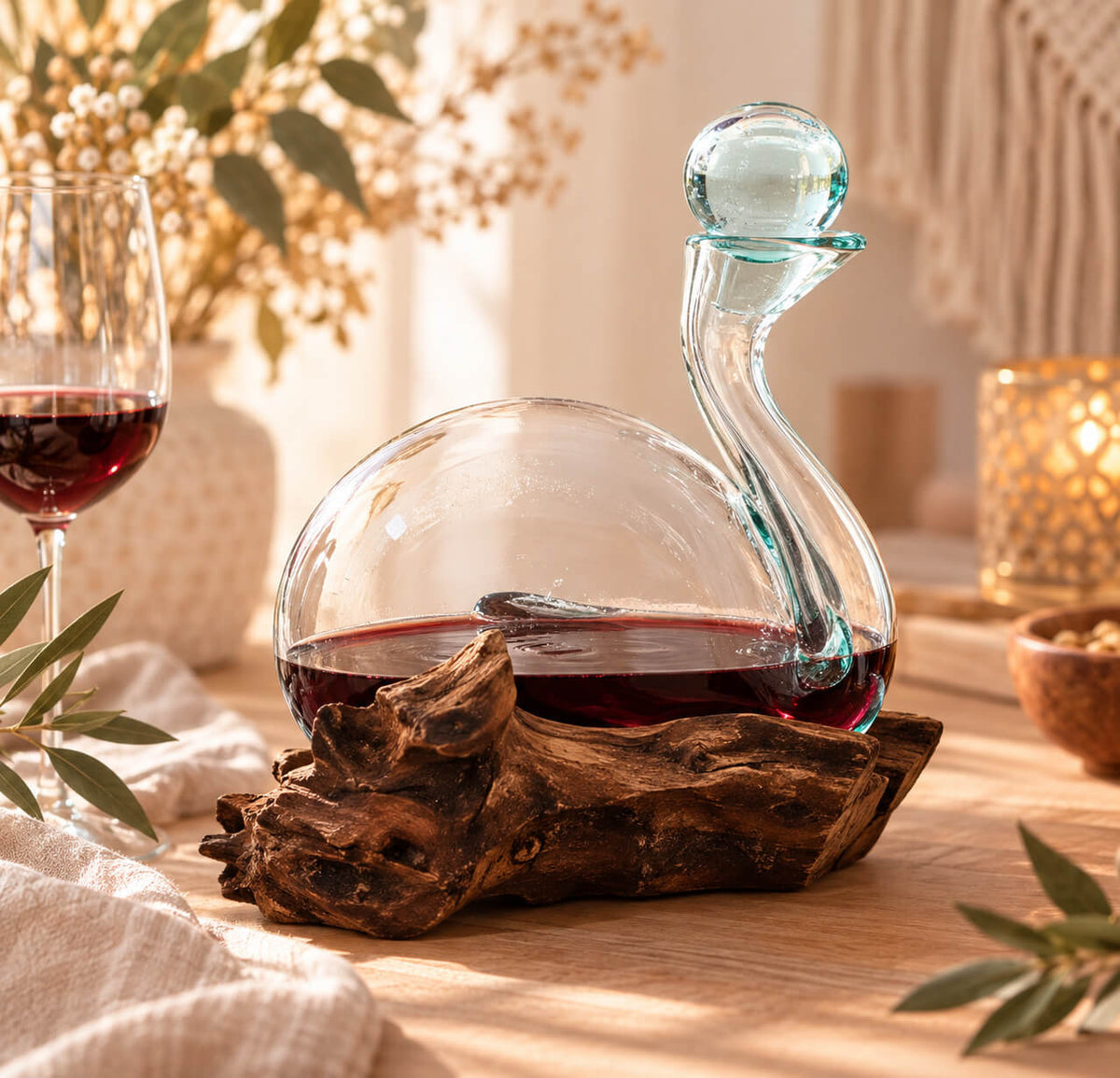 Décanteur en verre soufflé en forme de canard rempli de vin rouge, posé sur un socle en bois