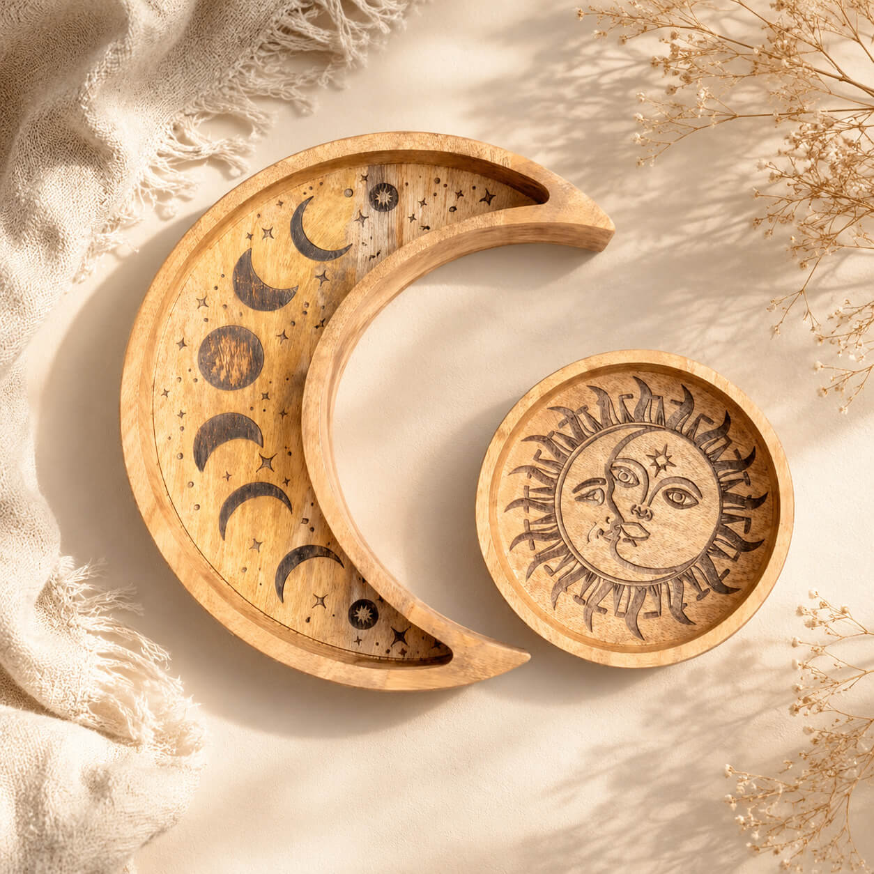 Duo de plateaux en bois gravé, l'un en croissant de lune, l'autre rond soleil.