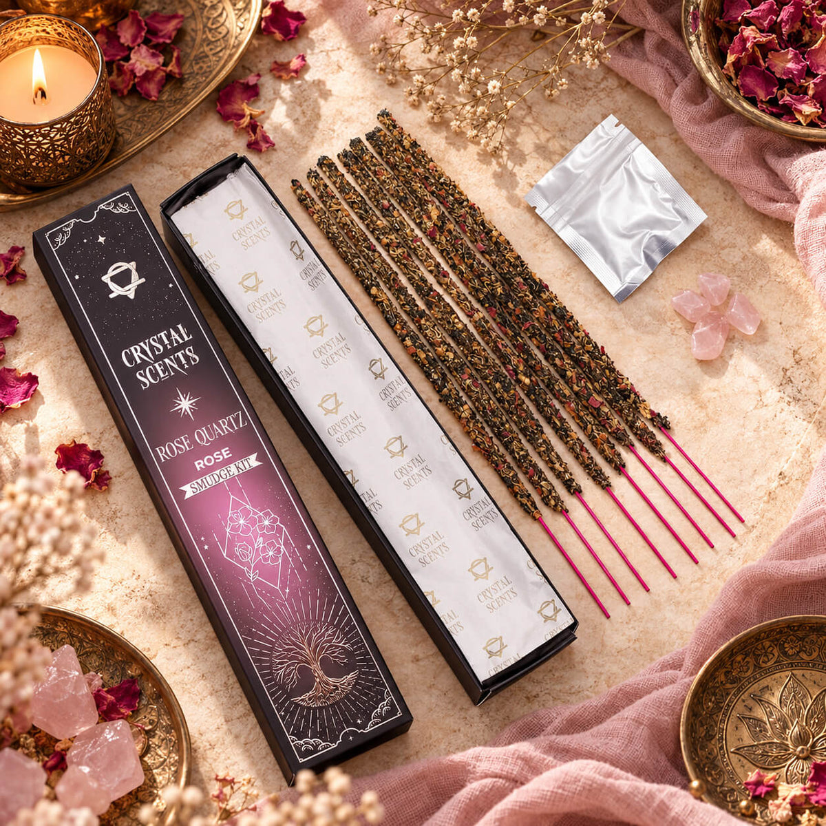 Encens à la rose en bâtonnets à tige rose vif, étui ouvert à côté d'un sachet et d'éclats de quartz rose, parmi des pétales séchés