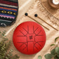 Grand tongue drum rouge craquelé avec sa housse de transport ethnique et ses mailloches en bois.