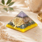 Grande pyramide en orgonite avec arbre doré, éclats de pierres multicolores et base ambrée