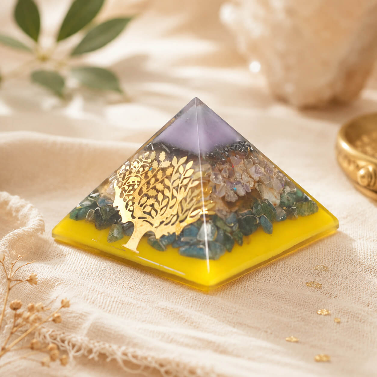 Grande pyramide en orgonite avec arbre doré, éclats de pierres multicolores et base ambrée