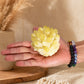 Grappe de quartz jaune fantôme tenue dans une main avec bracelets en pierres naturelles