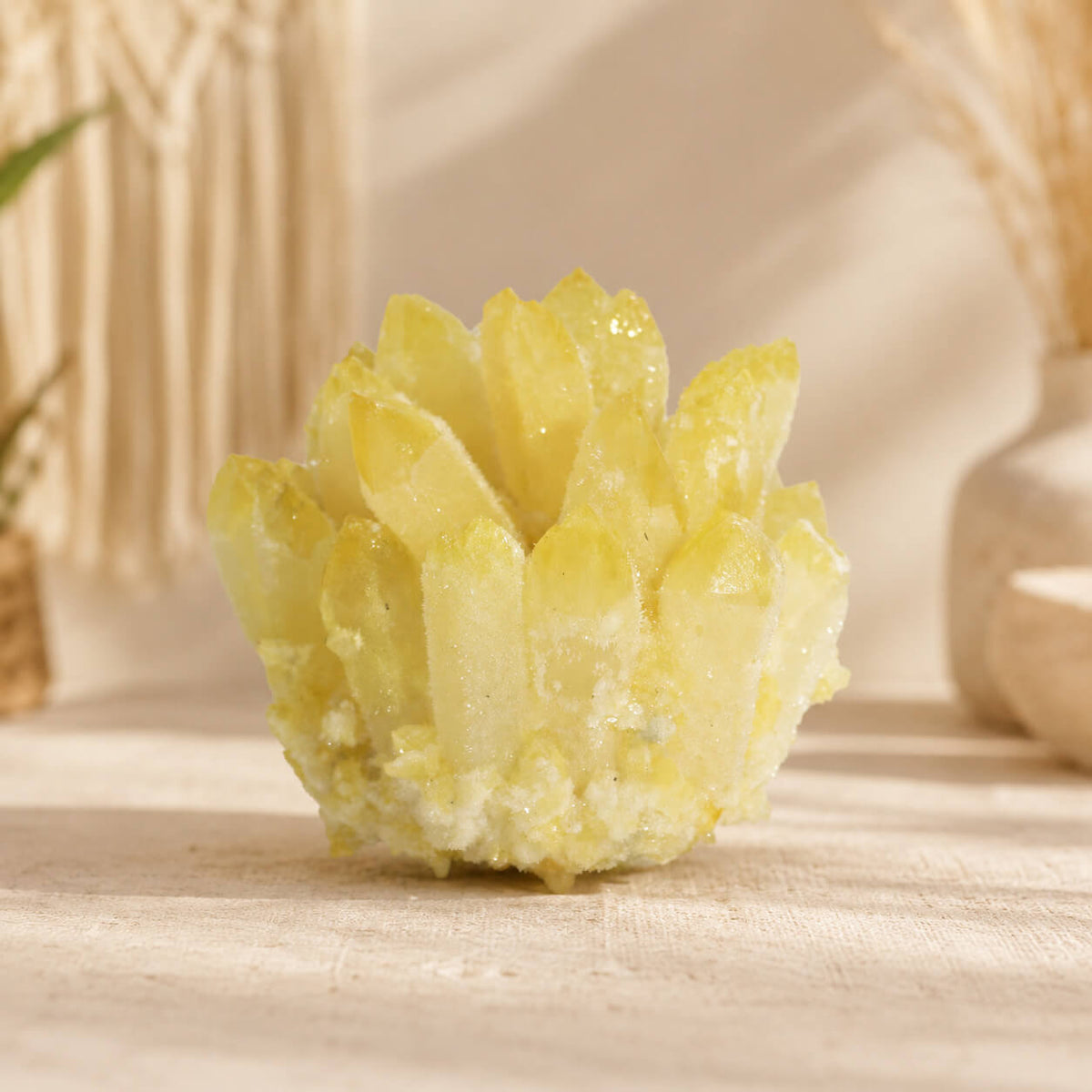 Grappe de quartz jaune fantôme aux pointes multiples posée sur table claire