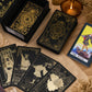 Jeu de tarot noir et or avec cartes étalées, boîte ouverte et livret illustré