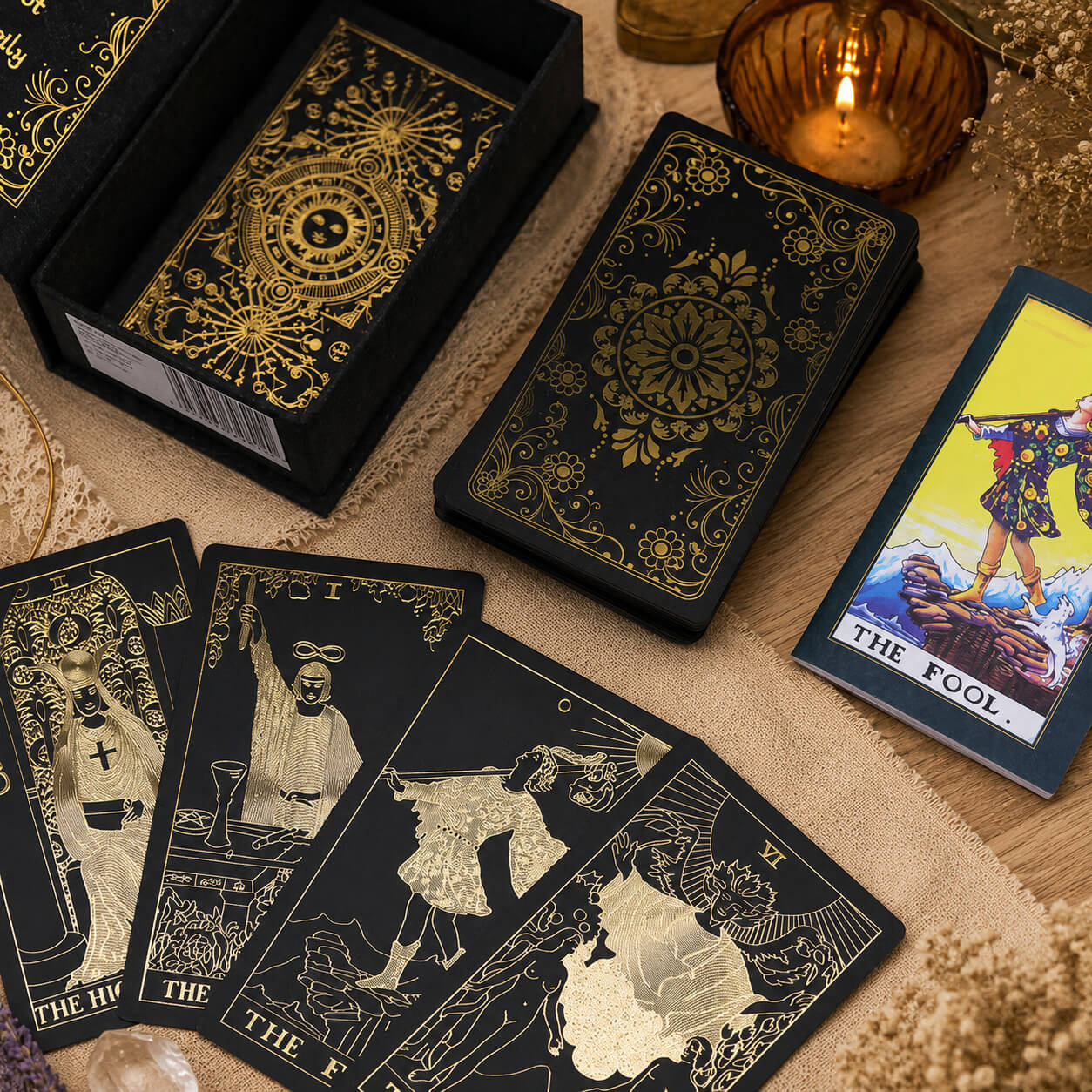 Jeu de tarot noir et or avec cartes étalées, boîte ouverte et livret illustré
