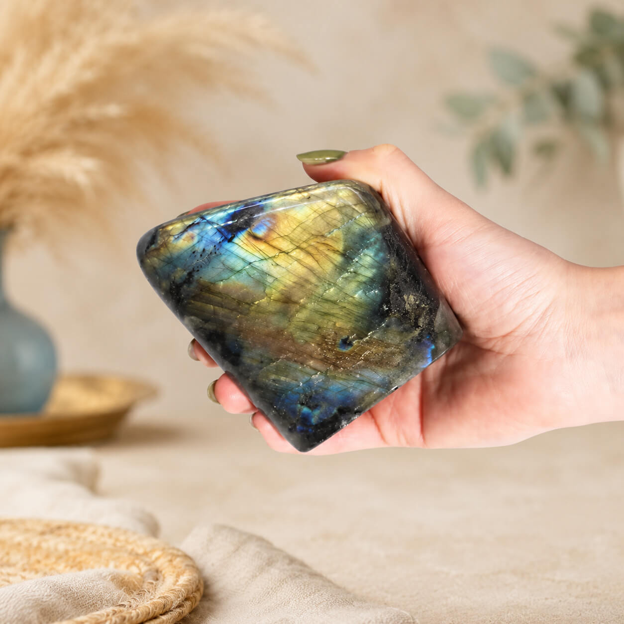 Labradorite naturelle polie tenue dans une main, reflets dorés visibles