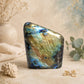 Labradorite naturelle polie aux reflets bleus et dorés posée sur table