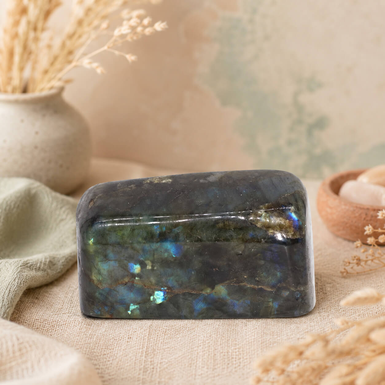 Labradorite naturelle polie petit format aux reflets bleus et verts posée sur table