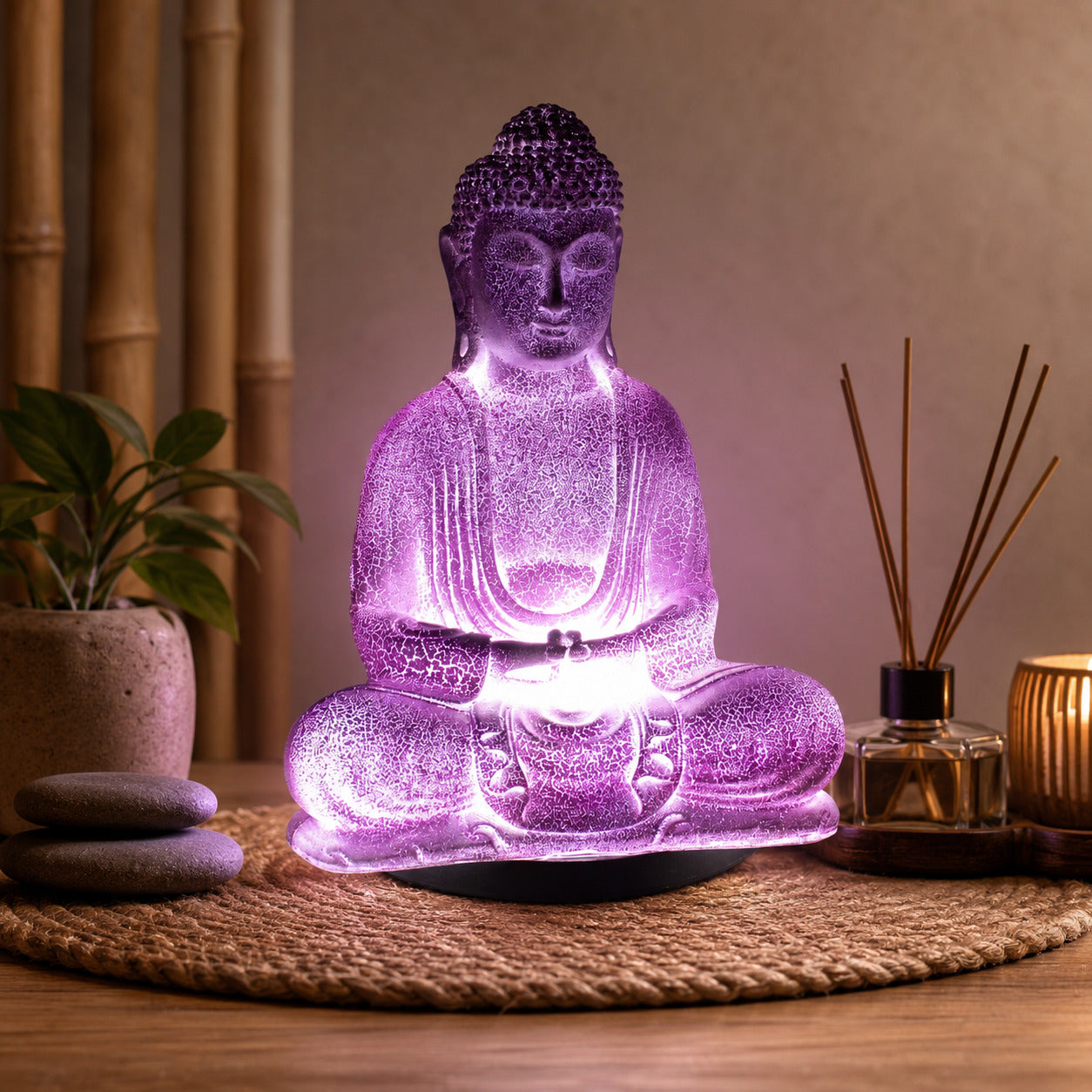 Lampe Bouddha lavande craquelée allumée diffusant une lumière violette dans un coin méditation.